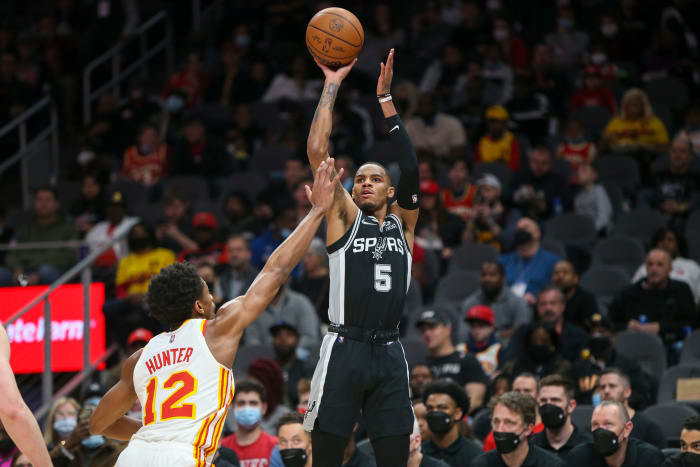 Feb 11, 2022; Atlanta, Georgia, USA; San Antonio Spurs guard Dejounte Murray (5) shoots over Atlanta Hawks forward De'Andre Hunter (12) in the first quarter at State Farm Arena.